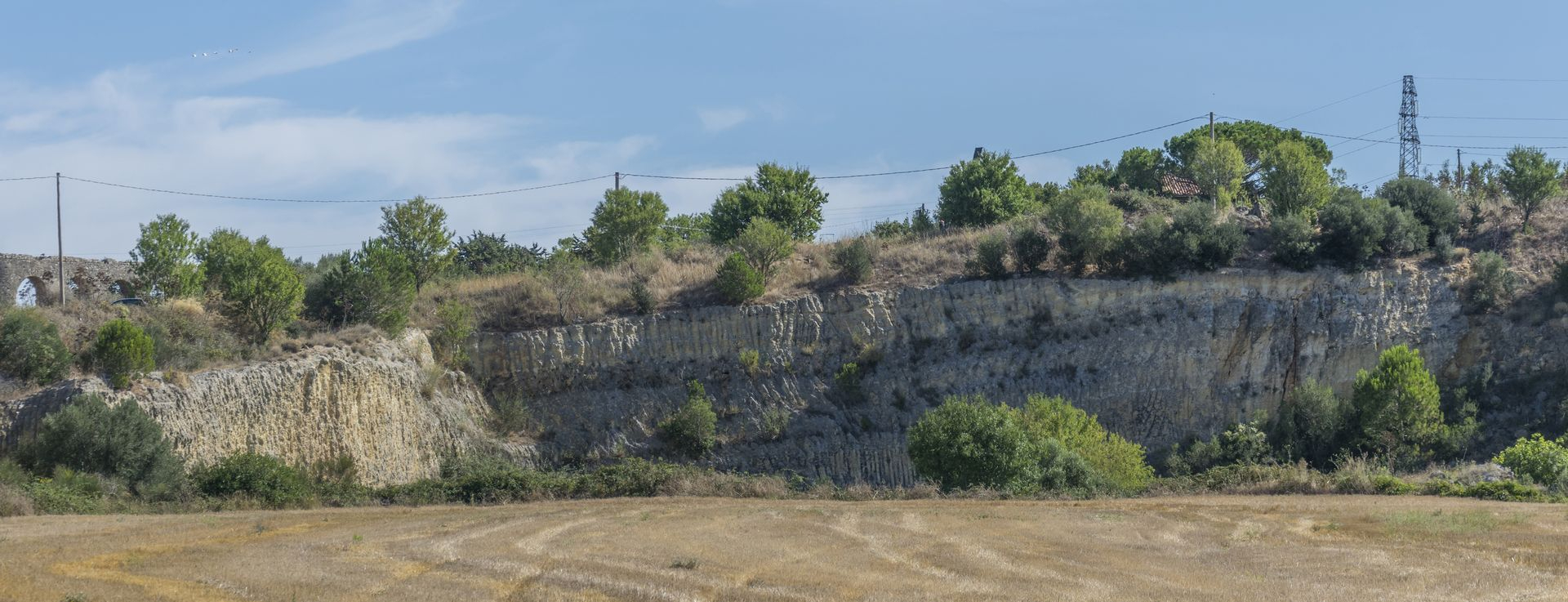 Il fronte di cava di Località Pisciarello: si notano distintamente i tagli verticali dovuti all'escavazione, i quali si contrappongono agli strati orizzontali di naturale deposizione.